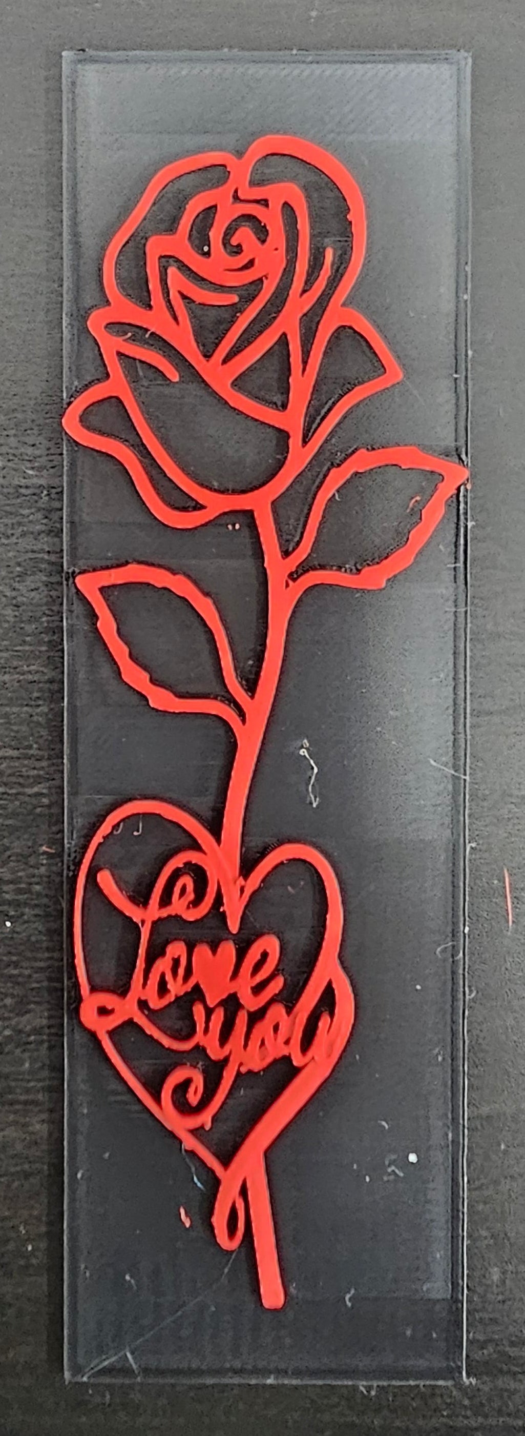 Red rose-shaped cutting dies on a block against a black background